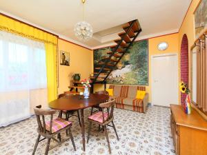 鲍洛通凯赖斯图尔Holiday Home Pomme by Interhome的用餐室设有黄色的墙壁和一张木桌及椅子