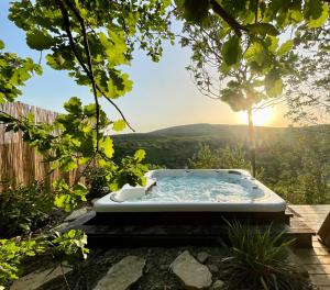 佩奇Modern cottage, views and a jacuzzi的花园内的热水浴池,享有日落美景