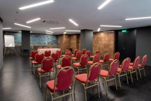 雅典阿斯图酒店的一间会议室,配有红色椅子和讲台
