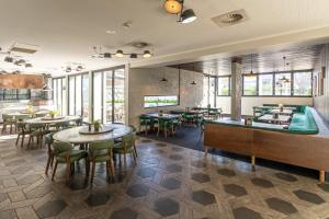 PananiaMill Hotel Milperra Panania的餐厅设有桌椅和窗户。