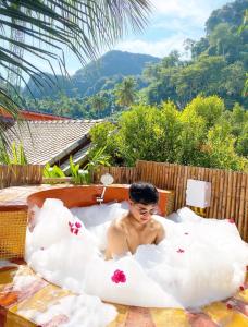 皮皮岛Phi Phi Maiyada Resort- SHA Certified的躺在云雾浴缸里的人