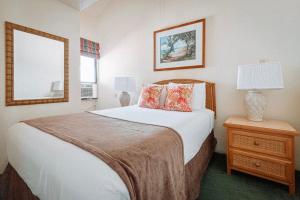 利胡埃Banyan Harbor Resort的一间卧室配有一张床和一张带台灯的桌子