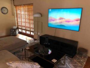 比勒陀利亚Executive suite with full kitchen & lounge的客厅的墙上配有平面电视。