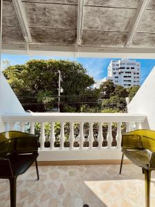 卡塔赫纳Peregrinos Hostel Cartagena de Indias的阳台配有白色栏杆和2把椅子