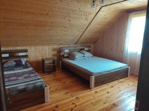 斯维季亚济Сімейний куточок的小木屋内一间卧室,配有两张床