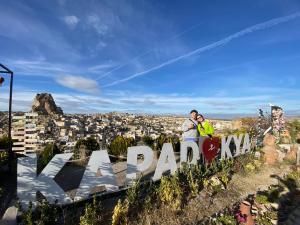 格雷梅Cappadocia Fairy Tale Suites的一对夫妇站在标志性的广场公园顶上