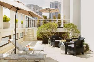布宜诺斯艾利斯安再尼卡塔套房酒店 的屋顶庭院配有桌椅和遮阳伞。