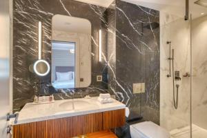 圣莫里茨Grand Hotel des Bains Kempinski的一间带水槽、镜子和卫生间的浴室
