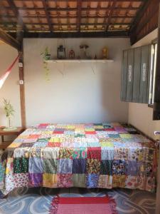 索雷Hospedagem Casinha do Solar的一张床上,床上有五颜六色的被子