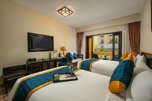 河内河内金月酒店的酒店客房设有两张床和电视。