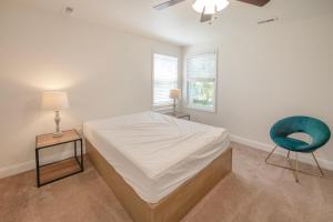 五月岬郡Sun Outdoors Cape May的一间卧室配有一张床和一张蓝色椅子