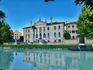 多洛ERMAN HOUSE - Naviglio Riviera del Brenta Venezia的水体旁边的旧建筑