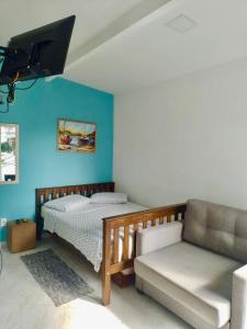 卡波布里奥FLAT / APARTAMENTO NA PRAIA DO FORTE的一间卧室配有一张床和一张沙发
