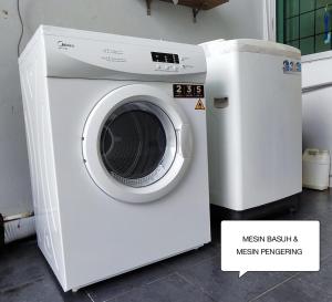MukahFarwis Homestay的客房内的白色洗衣机和微波炉