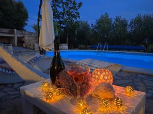 诺瓦利娅Villa Cesarica Novalja的一张桌子,上面放着一瓶葡萄酒和一杯