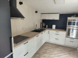 MarckHemmes Kiteland Beach House的厨房配有白色橱柜和炉灶烤箱。