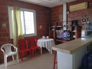 普拉亚斯A orillas del paraiso的厨房配有2把红色椅子和1张桌子。