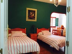 克鲁兹·德·特赫达蒙塔纳阿罗亚乡村旅馆的卧室设有两张床铺和绿色的墙壁