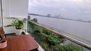 河内Hanoi Home 2 - Lake View Apartment的阳台配有桌子,享有水景