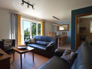 索尔布罗特Picture perfect Holiday Home in Sourbrodt with Garden BBQ的客厅配有蓝色的沙发和桌子