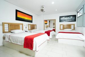 伊塔圭Hotel Portal Central的一间卧室设有三张床和一台平面电视