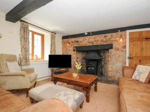 克雷迪顿The Thatched Cottage的带沙发和壁炉的客厅