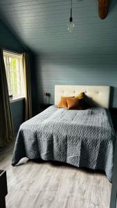 希恩Ladegaarden的一间卧室配有一张带灰色棉被的床和窗户