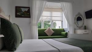阿拉恰特阿德尔菲亚酒店的客厅设有绿色沙发和窗户。