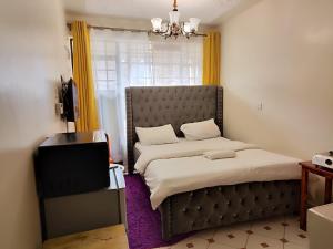 KikuyuSoft Life Crib in Kinoo with Wifi & Netflix的一间小卧室,配有一张床和电视