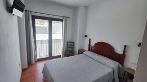 萨阿拉德洛斯阿图内斯Hostal Jadraza的一间卧室设有一张床和一个大窗户