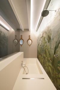 锡拉库扎ISONZO SUITES的一间带水槽的浴室和墙上的绘画