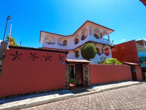 阿约拉港加拉帕戈斯套房住宿加早餐旅馆的前面有红墙的房子