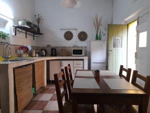 科洛尼亚-德尔萨克拉门托Casa Calma的一间带桌子的厨房和一间带冰箱的厨房