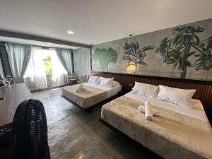 金巴亚Eco Hotel La Colina Mirador的一间卧室设有两张床,墙上挂着一幅画