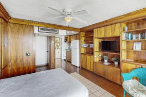 科纳Kona Magic Sands 107的客房设有一张床和一间带木制橱柜的厨房