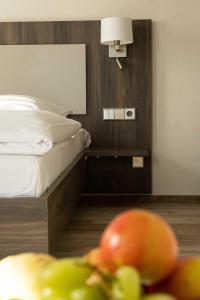 埃斯林根克尔特餐厅酒店的一间卧室配有一张床和一碗水果