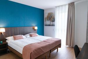 CollombeyAlp Art Hotel的一间卧室设有一张蓝色墙壁的大床