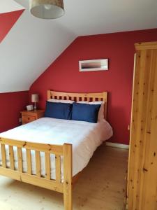 班多伦Bundoran Guesthouse的一间卧室配有一张红墙木床