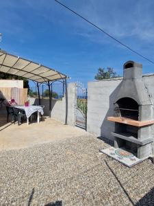 利卡斯戴勒Curmo beach & relax的一个带桌子的户外烤箱和一个庭院