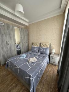 库塔伊西Rustaveli Apartment 113的一间卧室配有一张带蓝色棉被的大床