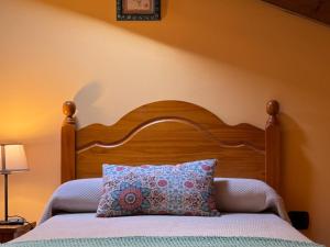 MonteCasa Rural El Salvijo的一张带木制床头板和枕头的床