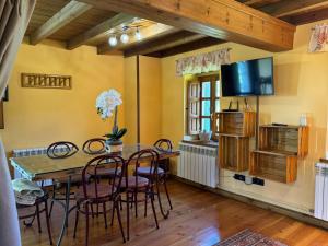 MonteCasa Rural El Salvijo的一间带桌椅和电视的用餐室