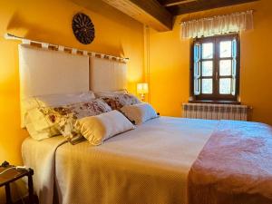 MonteCasa Rural El Salvijo的一间卧室设有一张大床、黄色的墙壁和窗户