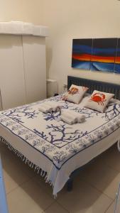Capo SperoneCasa Penny的一张带蓝色和白色毯子及枕头的床