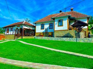 BoljevacEtno selo Stanojevic的前面有绿色草坪的房子