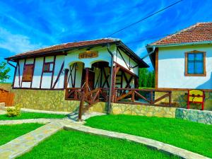 BoljevacEtno selo Stanojevic的庭院中带木门廊的小房子