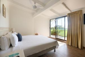 塔马林多Hotel Perla de la Playa的一间卧室设有一张床和一个大窗户