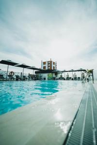 马拉加Hotel Málaga Nostrum Airport的一个带蓝色水和遮阳伞的游泳池