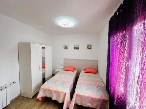 迈阿密普拉特亚Villa “Castellón“的一间卧室配有床和粉红色窗帘