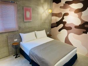 马公Midsummer Guest House的一间卧室配有一张带军事主题墙壁的床。